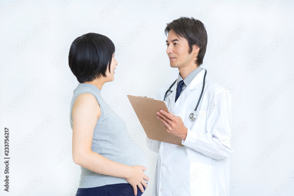 タンクトップの妊婦に問診する白衣の男性医師。産婦人科、妊娠、問診イメージ
