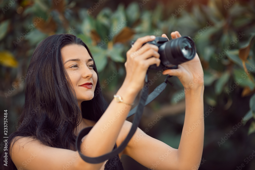 Attractive woman photographer taking images with dslr camera outdoors in park. Gorgeous happy mixed race Asian Caucasian female enjoying traveling outdoors during holidays in Europe. Attractive woman photographer taking images with dslr camera outdoors in park. Gorgeous happy mixed race Asian Caucasian female enjoying traveling outdoors during holidays in Europe.