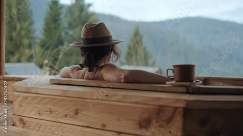 Young woman in an open air bath with view of the mountains.