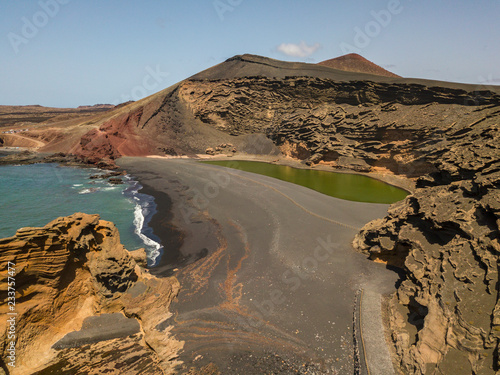 Vista aerea del Charco de los Clicos, lago dal colore verde smeraldo situato in una spiaggia di ciottoli neri, formazioni rocciose che costeggiano il lago. Lanzarote, Isole Canarie, Spagna