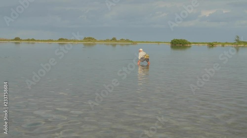 Man wading in a flat lagoon fishing for bonefish photo