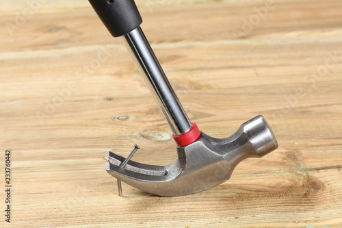 hammer pull out a bent nail fixed .in a wooden board