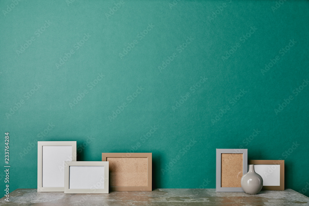 Different photo frames and vase on green background Different photo frames and vase on green background