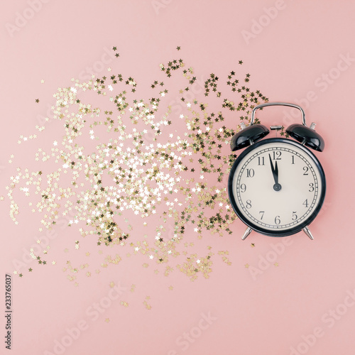 New Year concept. Alarm clock with golden confetti