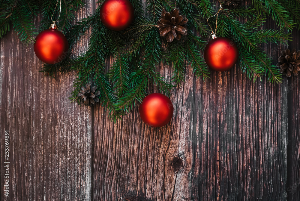 Christmas background with fir branches, red balls and pine cones on wooden. Traditional winter decor for new year with copy space. Flat lay top view Christmas background with fir branches, red balls and pine cones on wooden. Traditional winter decor for new year with copy space. Flat lay top view