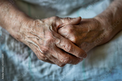 Hands of an old woman folded one over the other. Elderly woman with folded hands. Hands of an old woman close up. photo