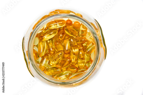 Capsules with omega3 in a glass vessel. View from above. Close-up.