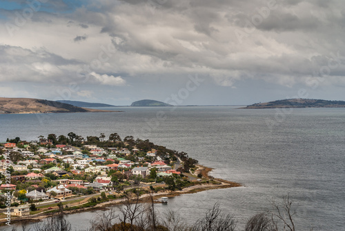 Hobart, Tasmania, Australia - December 13. 2009: Posh Bellerive neighborhood and peninsula across dowtown Hobart under cloudy gray sky. Looking towards the sea over gray water. photo