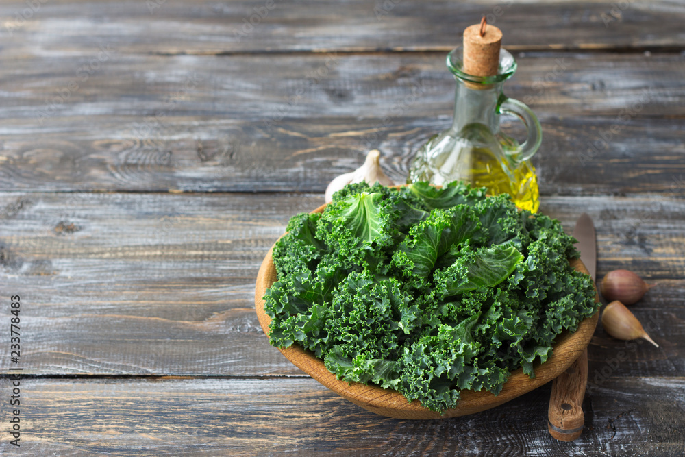 Ingredients for salad with kale, onion, garlic, olive oil on a wooden background, rustic style, free space, horizontal Ingredients for salad with kale, onion, garlic, olive oil on a wooden background, rustic style, free space, horizontal