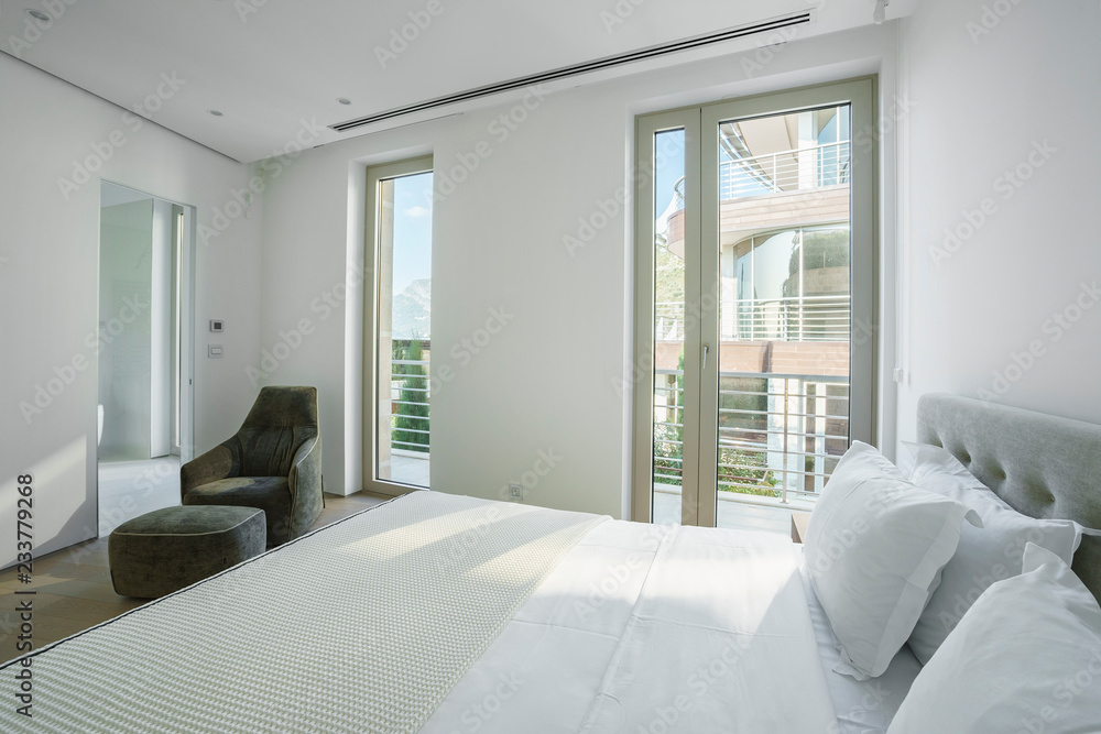 Fototapeta premium Interior of a spacious light bedroom with windows in a luxury villa
