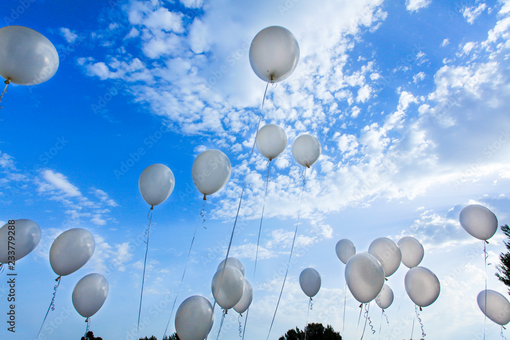 Foto Stock tanti palloncini bianchi che volano su nel cielo blu