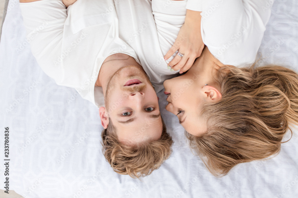 man and woman are spending their weekends on the bed. close up top view photo. relationship concept.
