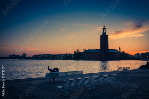 Silhouette of man and woman sitting on bench, Stockholm, Sweden