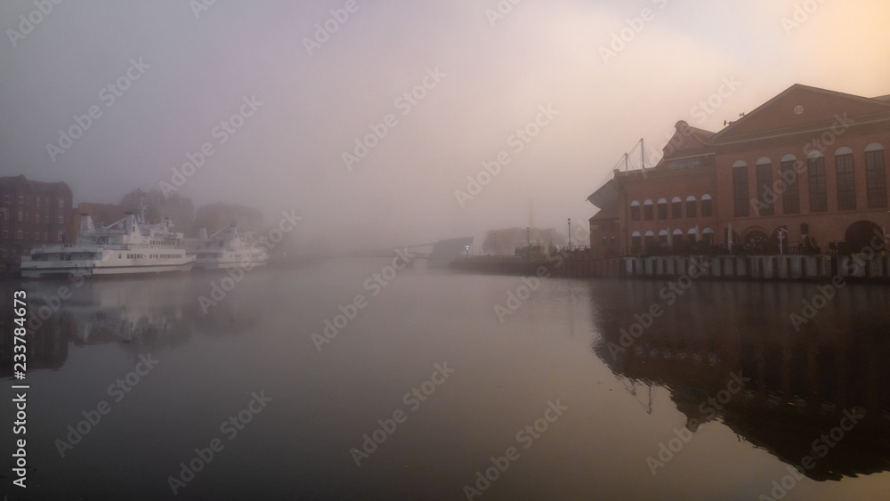Obraz premium Motlawa River embankment in Gdansk, misty weather.