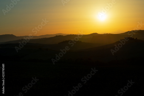 Amazing sunset in Tuscany, Italy, Europe. Beautiful landscape with sunset among the tuscan hills..