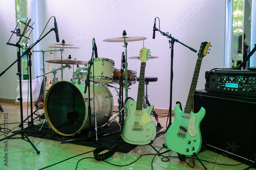 Empty stage with instruments ready for performance: drums set, guitars, bass and music desk