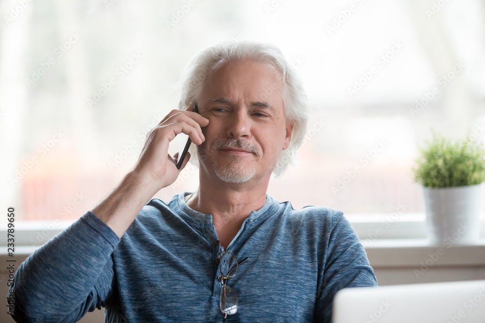 Proud senior man talking on cell phone having pleasant conversation at home, satisfied aged male happy speaking over smartphone relaxing in chair. Elderly using new technologies concept Proud senior man talking on cell phone having pleasant conversation at home, satisfied aged male happy speaking over smartphone relaxing in chair. Elderly using new technologies concept