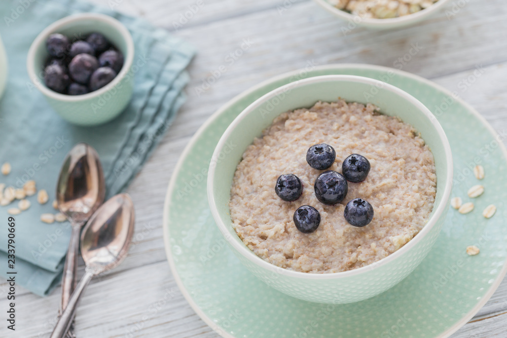 Oatmeal porridge bowl on the white wooden background. Oatmeal porridge bowl on the white wooden background.
