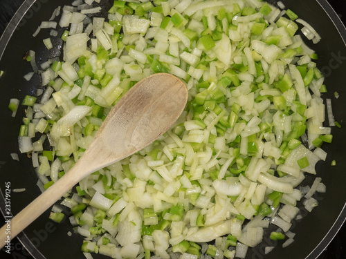 Fotografi onion and green pepper fried in a pan