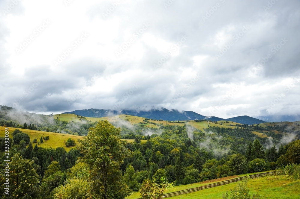 Beautiful summer landscape with mountains and dark sky covered with stormy clouds