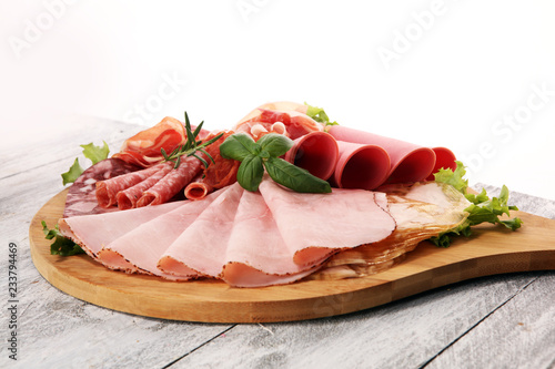 Food tray with delicious salami, pieces of sliced ham, sausage and salad. Meat platter with selection.