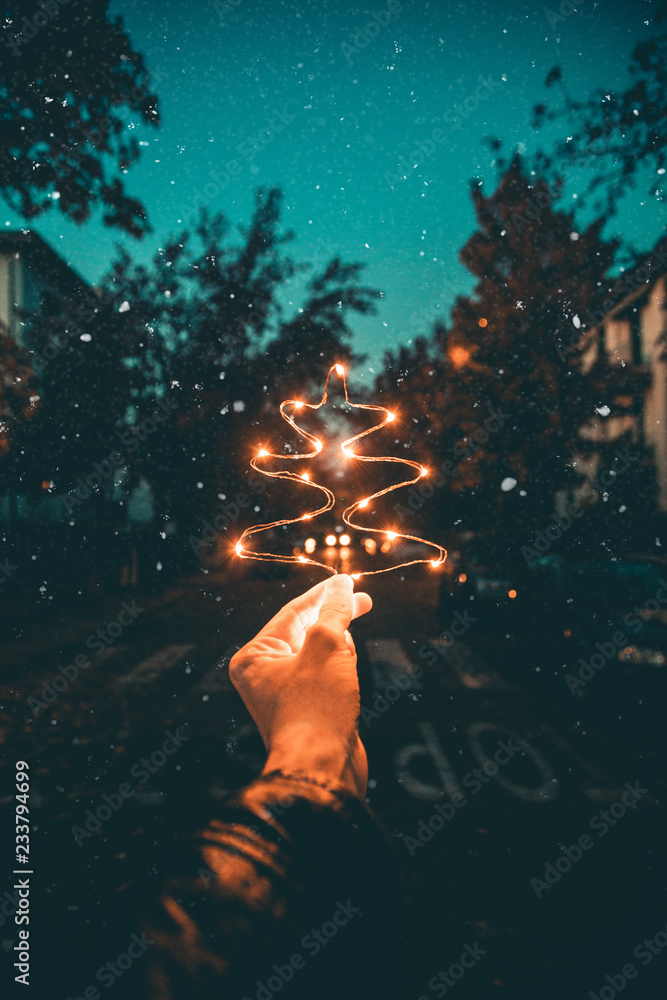 Fototapeta premium Albero di natale realizzato con simbolo di luci led in una strada innevata.