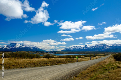 Mountainbikers ride a race on a long gravel road hear Puerto Natales, Patagonia Chile.