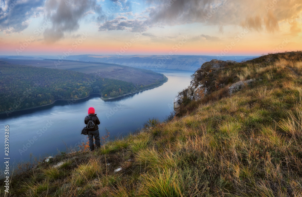 tourist on the mountain above the river. the girl looks at the picturesque canyon. autumn morning on the river Dniester