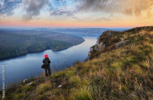 tourist on the mountain above the river. the girl looks at the picturesque canyon. autumn morning on the river Dniester © sergnester
