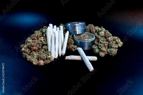 Obraz na płótnie Marijuana joints stacked on a pile of bud with a blue coloured bud grinder. w salonie