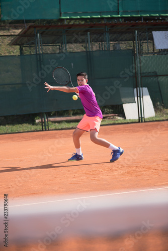 Young tennis player hitting the ball