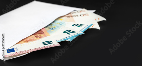 Envelope with euro bills on black.