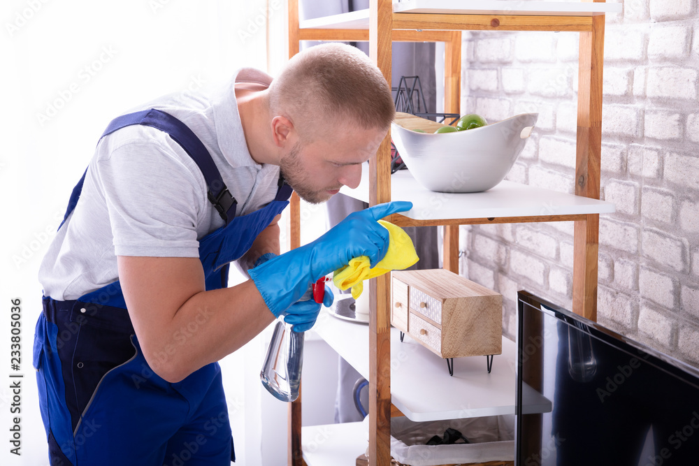 Young Male Janitor Cleaning Shelf Young Male Janitor Cleaning Shelf