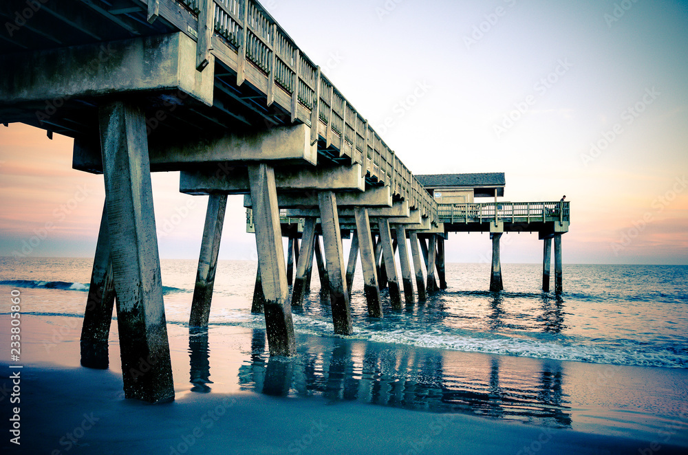 Wide angle view of the Tybee Island Pier in Georgia. Colorful sunset with pinks and purple colors in the sky