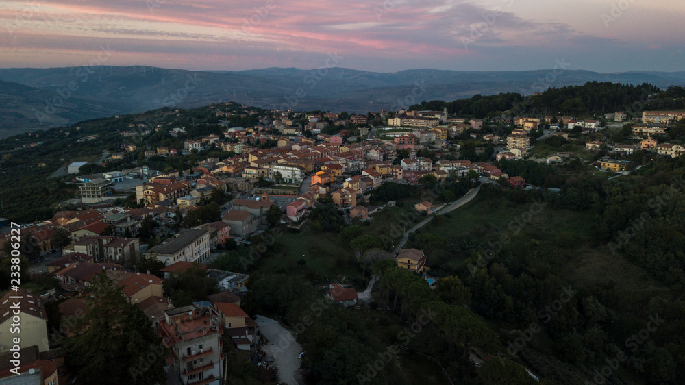 Aerial view at sunset of the small town of Montecalvo Irpino, in the province of Avellino, in Italy. This village with few houses and streets is built in the mountains of Irpinia.