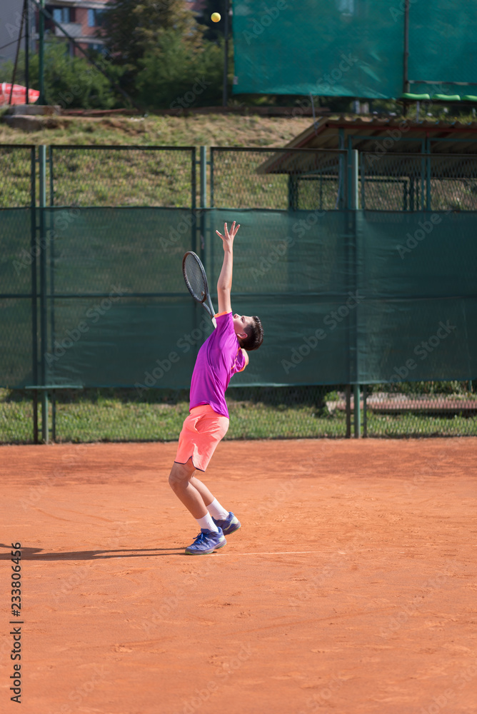 Young tennis player serving the ball
