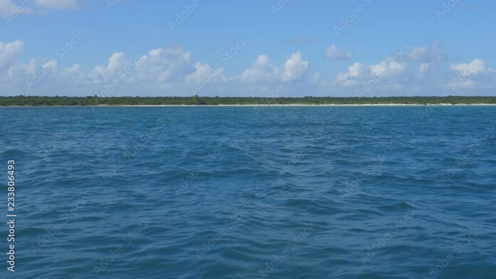 Slow motion view from boat with turquoise ocean, and deserted beaches and coastline in the distance. Mayan Riviera, Quintana Roo, Mexico. Slow motion view from boat with turquoise ocean, and deserted beaches and coastline in the distance. Mayan Riviera, Quintana Roo, Mexico.
