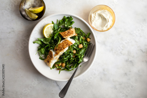 Fried halibut fist with spiced chickpeas and hen salad served on plate photo