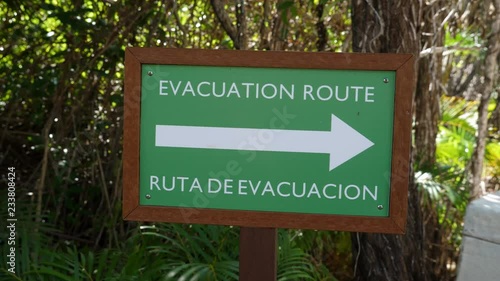 Evacuation Route sign in English and Spanish. Sign showing direction of evacuation route in event of natural disaster at resort in Quintan Roo, Mexcio.