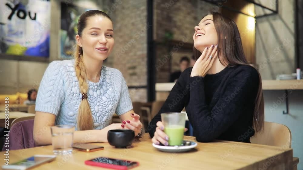 Women friends having breakfast talking in a cafe Women friends having breakfast talking in a cafe