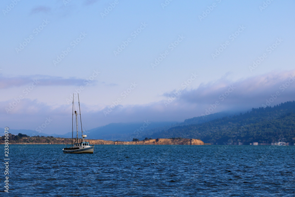 Beautiful view of the ocean and the mountains with a small yacht