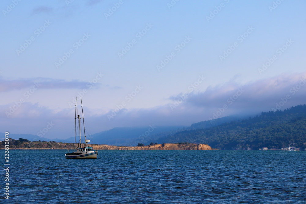 Beautiful view of the ocean and the mountains with a small yacht Beautiful view of the ocean and the mountains with a small yacht