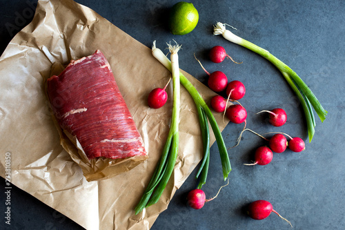 Close up of flank steak with scallions, radish and lemon photo