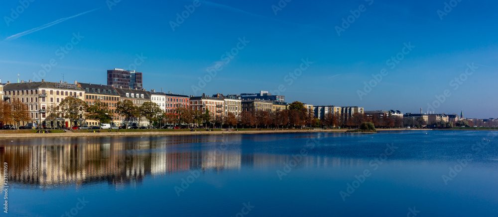 Colorful houses and building reflecting on the artificial lakes in Copenhagen in a warm Autumn day