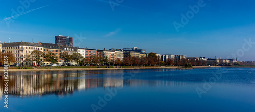 Colorful houses and building reflecting on the artificial lakes in Copenhagen in a warm Autumn day © gdefilip