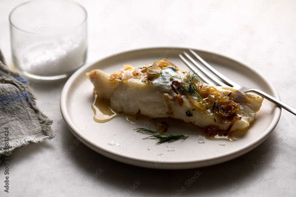 Close up cod with braised shallots and yogurt served on plate Close up cod with braised shallots and yogurt served on plate