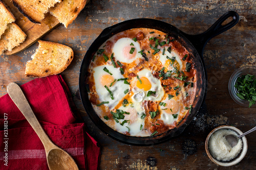 Overhead view of Shakshouka in frying pan on wooden table