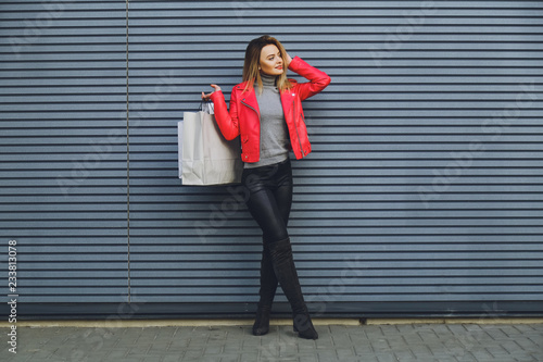 Young beautiful blonde girl with purchases, packages after shopping