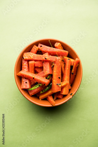 Carrot Pickle / Gajar ka Achar or Loncha in hindi. Served in a bowl over moody background. Selective focus