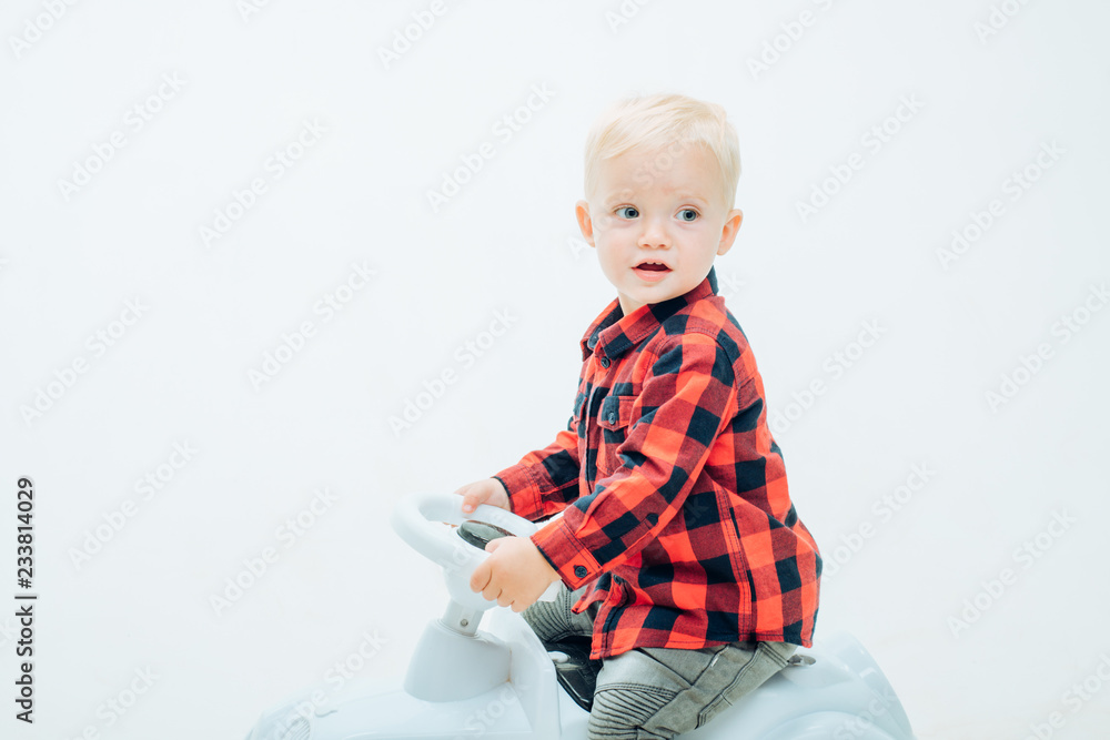 Fun but safe. Little baby enjoy playing in kindergarten. Little child ride on toy car. Boy child on riding toy. Small toddler builds balance and motor skills. Child day care or nursery, copy space Fun but safe. Little baby enjoy playing in kindergarten. Little child ride on toy car. Boy child on riding toy. Small toddler builds balance and motor skills. Child day care or nursery, copy space